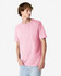 A pink heavyweight cotton unisex T-shirt displayed on a model, featuring a relaxed fit and short sleeves.