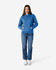 A blue hooded sweatshirt paired with jeans, featuring a front pocket and drawstring hood, modelled by a woman.
