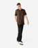 A unisex short sleeve T-shirt in brown, displayed by a model, paired with dark cargo pants and footwear.