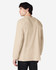 A man wearing a beige Gildan Ultra Cotton long sleeve T-shirt, viewed from the back. The shirt features a logo.