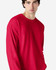 A red long sleeve t-shirt with a relaxed fit, featuring a logo on the front.
