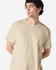 A beige Gildan Heavy Cotton Adult T-Shirt on a model, featuring a round neckline and a logo.