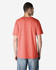 A person wearing a coral Gildan Heavy Cotton Adult T-shirt, viewed from the back, showcasing its simple design.