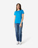 A woman wearing a bright blue Gildan Heavy Cotton Ladies' T-Shirt and jeans, standing against a plain background.