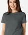 A grey Gildan Heavy Cotton Ladies' T-Shirt displayed on a smiling woman, featuring a simple design and soft fabric.