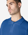 A blue Gildan Softstyle adult double pique polo shirt on a model, featuring a collar and buttons, with a logo.