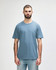 A light blue midweight t-shirt worn by a male model, featuring a simple design and a logo.
