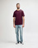 A maroon Gildan Softstyle adult midweight T-shirt displayed on a model, paired with black jeans and sneakers.