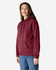 A burgundy adult hooded sweatshirt, featuring a front pocket and a drawstring hood. The model stands casually.