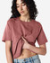 A model wearing a boxy, short-sleeved fine jersey T-shirt in a muted rose colour, paired with light denim shorts.