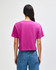 A women's fine jersey boxy T-shirt in magenta colour, featuring a plain back design. The model wears denim jeans.