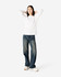A model wearing a white heavyweight cotton unisex long sleeve T-shirt paired with blue jeans and white shoes.