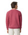 A crewneck sweatshirt in a deep pink shade, featuring a simple design and ribbed cuffs at the wrists.