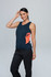 A woman wearing a navy singlet with orange accents, standing with one hand on her head, and dressed in black pants.