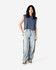 A navy blue women's muscle t-shirt is paired with light blue baggy jeans. The model stands in a neutral setting.