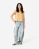 A mustard women's muscle T-shirt paired with light blue baggy jeans, featuring a logo.