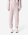 Unisex sweatpants in soft pink, featuring an elastic waistband and cuffs, shown with a pair of sneakers.