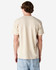 A beige unisex Henley T-shirt with short sleeves and a simple design, featuring a logo on the back.