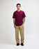 A model wearing a maroon heavyweight T-shirt and olive green cargo pants, featuring a logo.