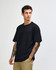 A model wearing a black American Apparel Super Heavyweight T-Shirt, paired with olive green cargo pants.