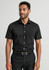 A short sleeve black button-up shirt with a pocket, worn by a man paired with dark trousers.