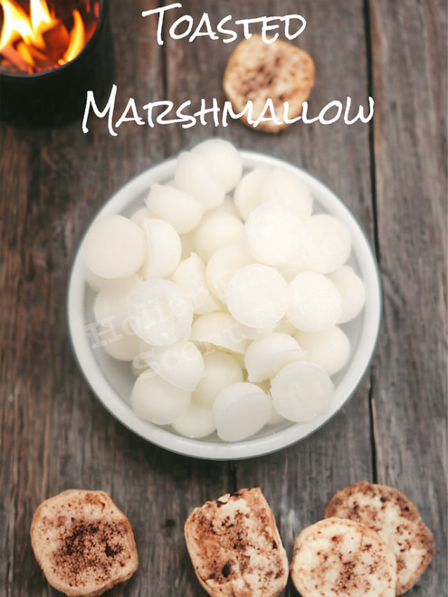 A rustic wood background with a container of white wax bits surrounded by toasted marshmallows.