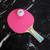 Tiger PingPong vice pink paddle with white ball on it.