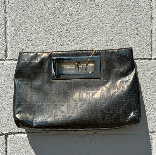 Eye-catching metallic finish gives this clutch instant glam, while the signature MK monogram print keeps it unmistakably chic. Compact yet roomy enough for your essentials, it's finished with polished gold-tone hardware for a refined, put-together look. The perfect grab-and-go piece for date night, dinner out, or dressing up any occasion.