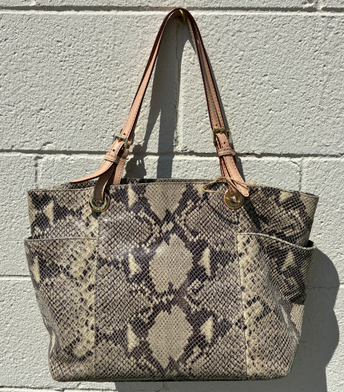 Eye-catching python print gives this tote a fierce, fashion-forward edge while staying totally wearable for everyday life. Signature Jet Set hardware and a structured silhouette keep it polished, with plenty of interior space for work, travel, or everyday essentials. A statement bag that's as functional as it is fabulous.