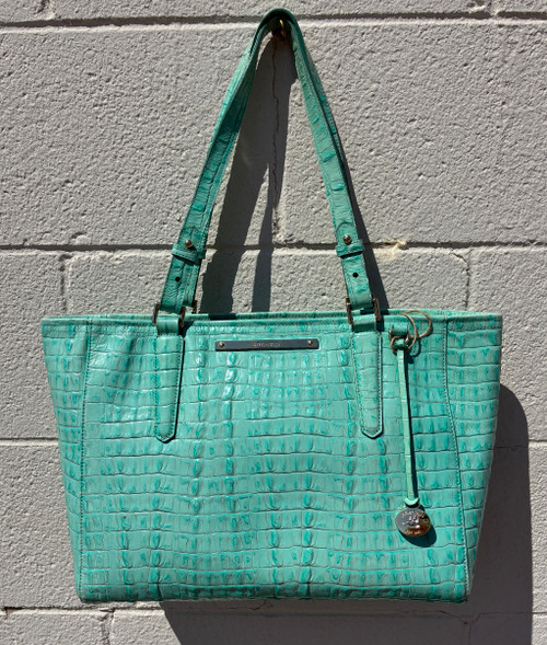 Straight out of a mermaid's dream, this tote's rich aquamarine hue shimmers with dimension and depth, showcasing Brahmin's signature embossed leather craftsmanship. Structured yet spacious, it's built for real life with sturdy handles and a roomy interior that fits everything you need for work, travel, or everyday adventures. A true statement piece that turns heads with every wear.
