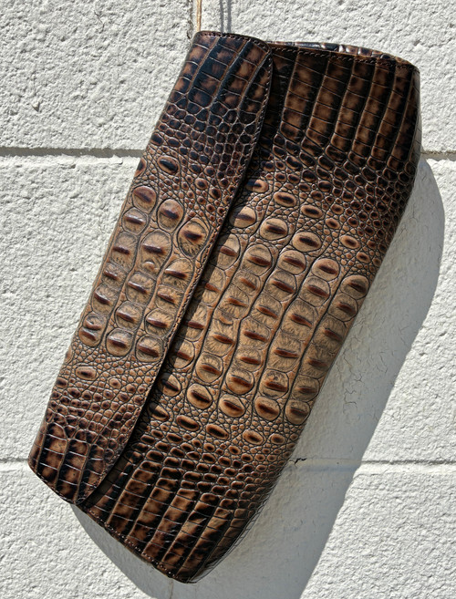 Rich, embossed alligator texture gives this clutch an instantly luxe look, finished in a deep, versatile brown that pairs with everything. Sleek and compact, it's the perfect grab-and-go piece for elevating any outfit — from a night out to a polished daytime look. A timeless statement piece with serious texture and refined style.