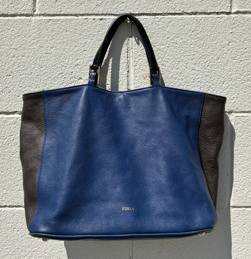 Sleek and sculptural, this tote showcases Furla's iconic Italian craftsmanship with clean lines and a structured silhouette. The convertible handle design offers effortless styling versatility, while the spacious interior keeps you organized for work, travel, or everyday essentials. A polished, timeless piece that elevates any outfit with understated Italian elegance.
