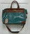 A striking gator-embossed texture in a rich dark teal and brown colorway gives this weekender bag serious statement appeal. Spacious and sturdy, it's the perfect travel companion for a quick getaway or everyday overnight essentials.