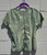 This sage green leather tee blurs the line between fashion and art, offering a sleek, modern silhouette in luxuriously soft leather. A true statement piece that elevates any outfit, the kind of design that feels more like wearing a sculpture than a shirt.