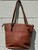 Rich rust-brown hues give this tote instant seasonal appeal, striking the perfect balance between classic and on-trend. Roomy and structured, it's built for everyday function with sturdy handles and signature Tommy Hilfiger detailing for a look that's effortlessly polished. A versatile go-to that layers beautifully into fall and winter wardrobes alike.
