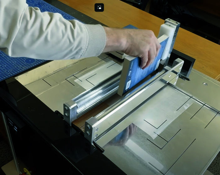 A school book being professionally covered using the CoverPro system