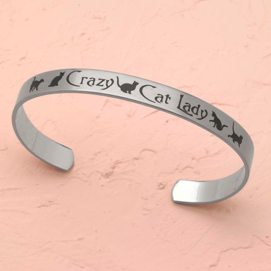 Stainless steel cuff bracelet with minimalistic silhouette of playful cats, featuring the text 'Crazy Cat Lady' surrounded by paw prints.