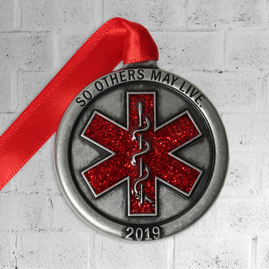 Red glitter enamel caduceus Christmas ornament with the words "So Others May Live" across the top.