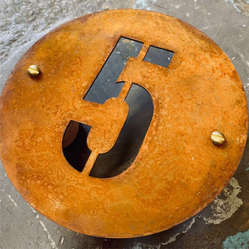 A round Corten house number. Round rusty steel sign - ideal for house numbers.