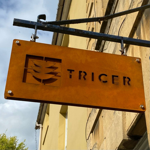 A triple layer Corten projecting sign, made up of three layers of Corten steel so the images can be seen from both sides.