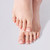 Feet with white French tip press-on toenails showing a clean, natural-looking pedicure