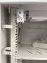 Close-up of cabinet ventilation filters and dual thermostat-controlled fans for temperature regulation