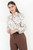 Blusa manga larga en satin estampado con cuello neru retorcido y escote V