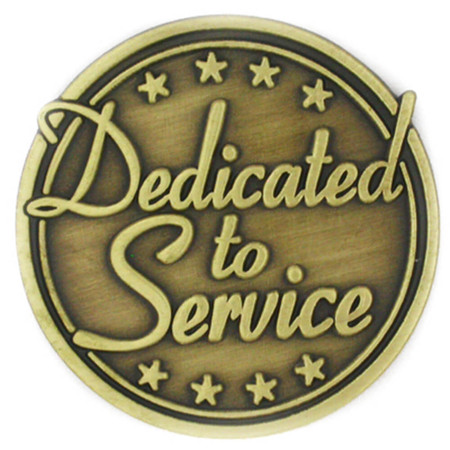 Round antiqued bronze lapel pin, metal color only, text says dedicated to service with star icons at the top and bottom edge - Front view