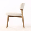 Side profile of the Royston Dining Chair highlighting its curved upholstered backrest and elegant natural timber structure.