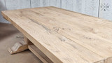 The Charlested Oak Dining Table bathed in sunlight, enhancing the rich, natural color of the wood