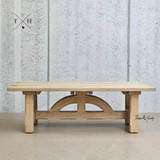 Front view of the Trailbridge Canyon Greige Wash Oak Coffee Table showcasing its elegant and sturdy design with a detailed arch base.