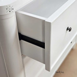 Close-up of the drawer handle detailing the elegant hardware and metal drawer runner