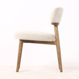 Side profile of the Royston Dining Chair highlighting its curved upholstered backrest and elegant natural timber structure.