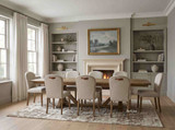 A luxury timber dining table with extension leaves and architectural trestle legs